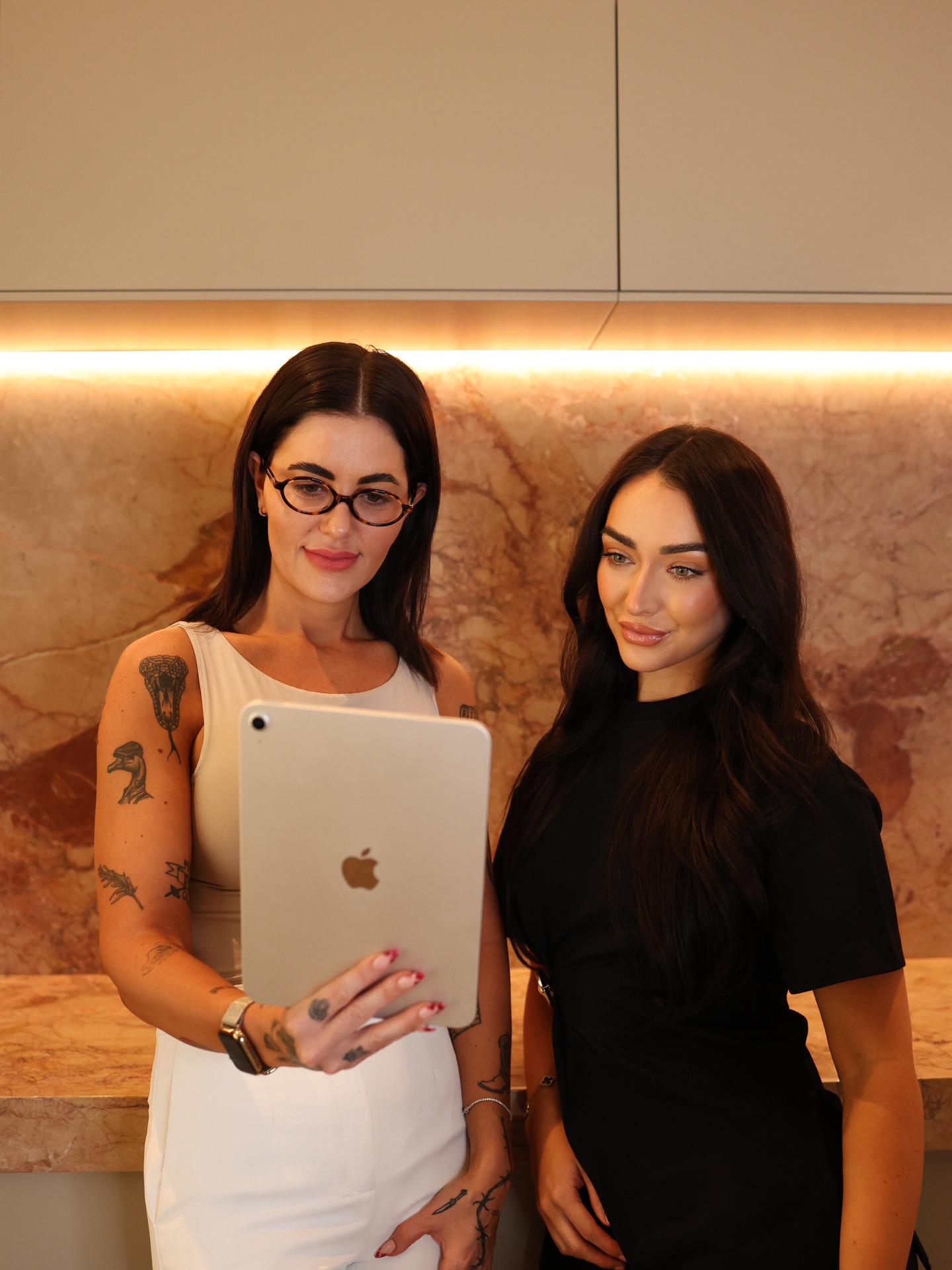 Practitioner and client reviewing a tablet during a consultation at Blume Aesthetics